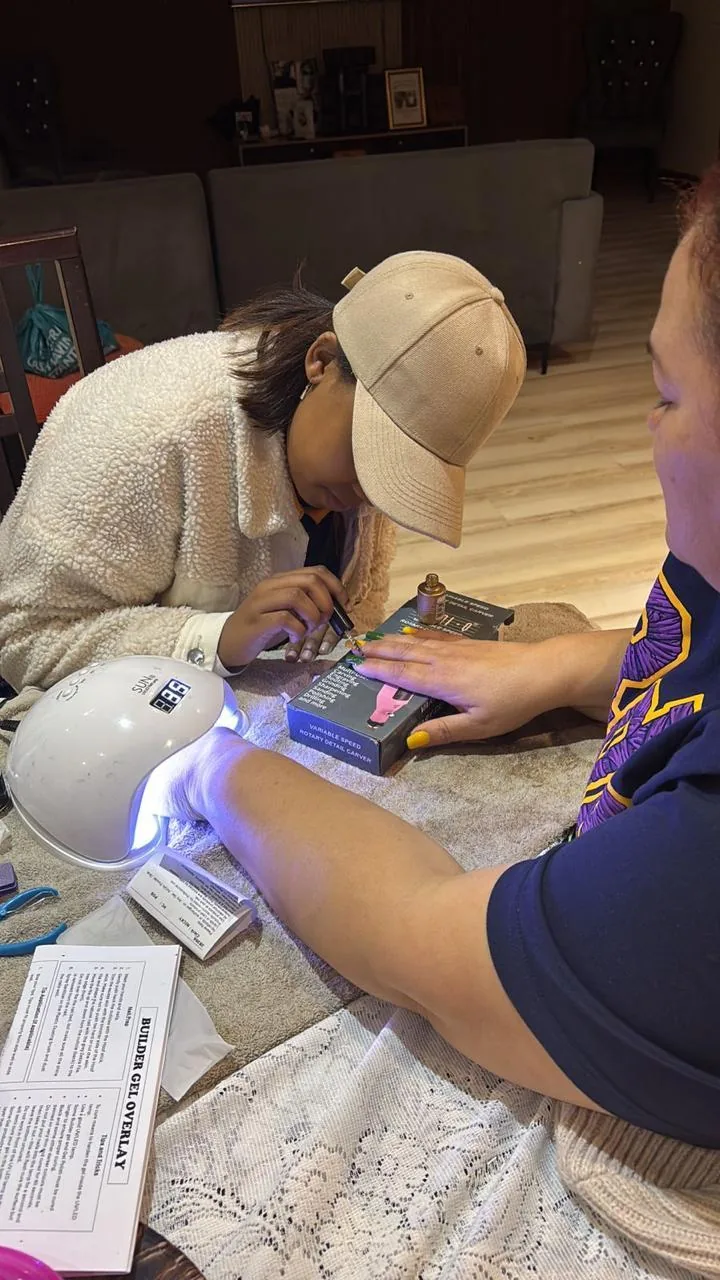 D at her studio table with the lamp on