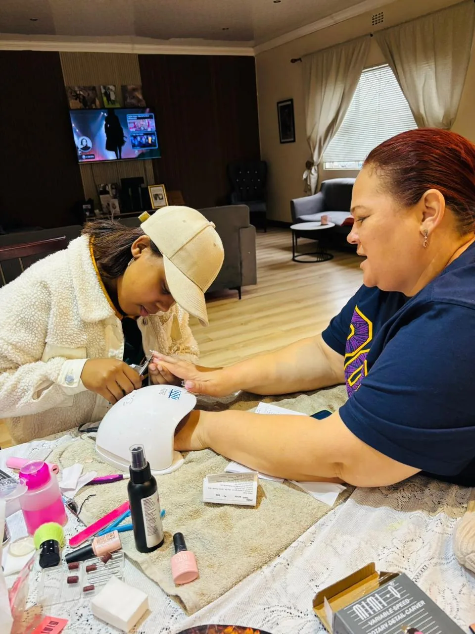 D carefully working on a client's nails